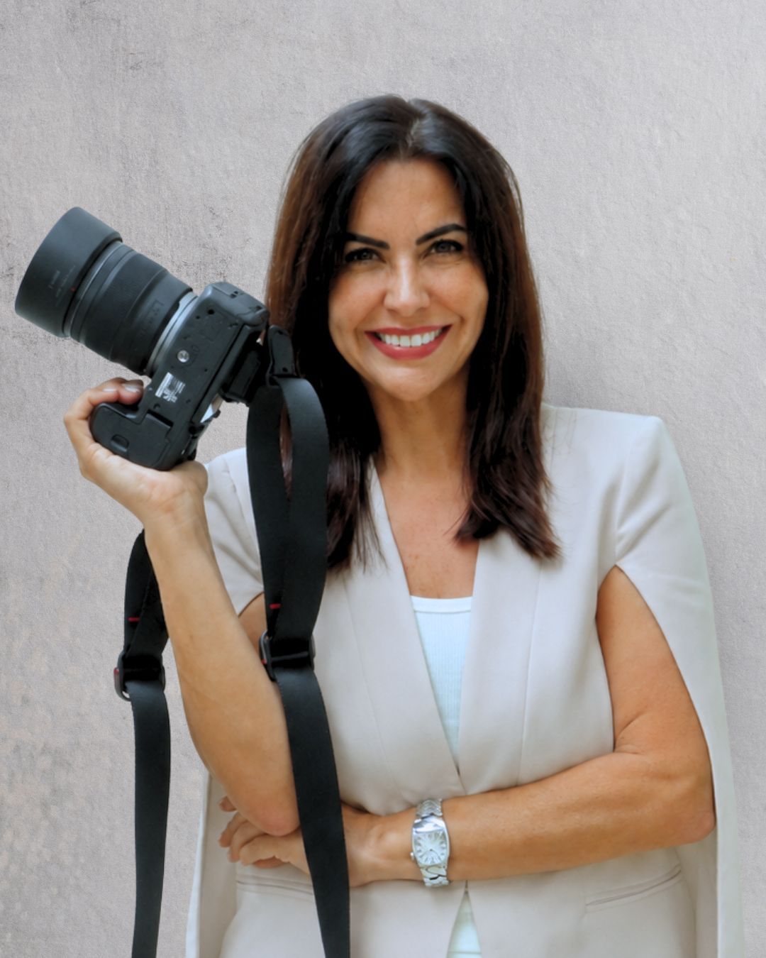Retrato de una persona con chaqueta negra y camisa blanca, iluminada por la cálida luz del sol contra una pared gris.