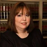 A woman wearing earrings is smiling for the camera