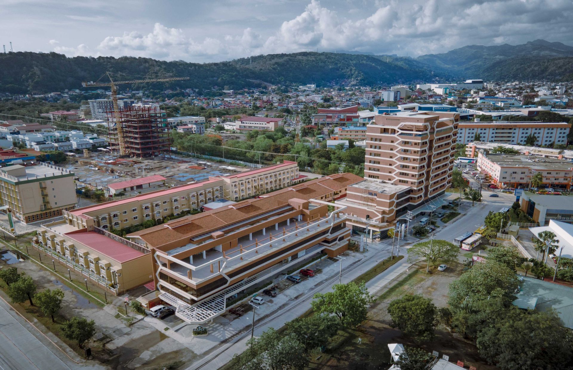 Aerial view of a city with apartment buildings, roads, and mountains in the background