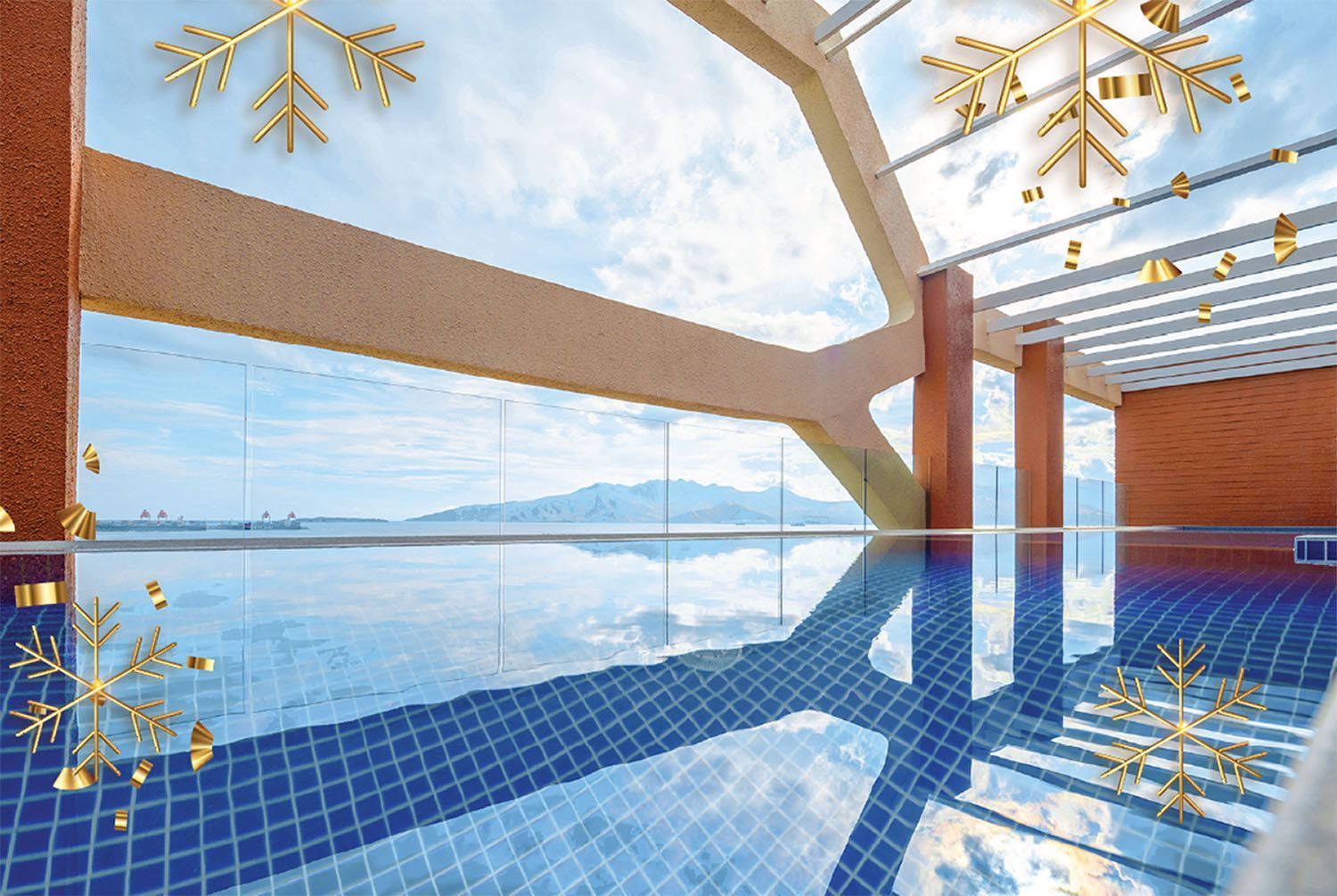Indoor infinity pool with blue water, ocean view, and wooden beams under a bright skylight