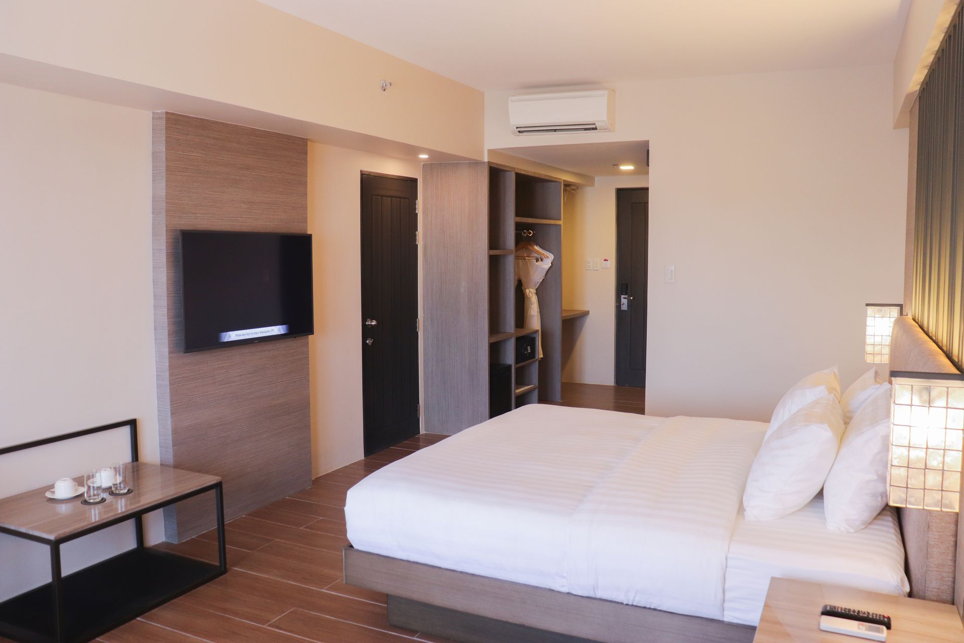 A hotel room with a large bed and a flat screen tv.