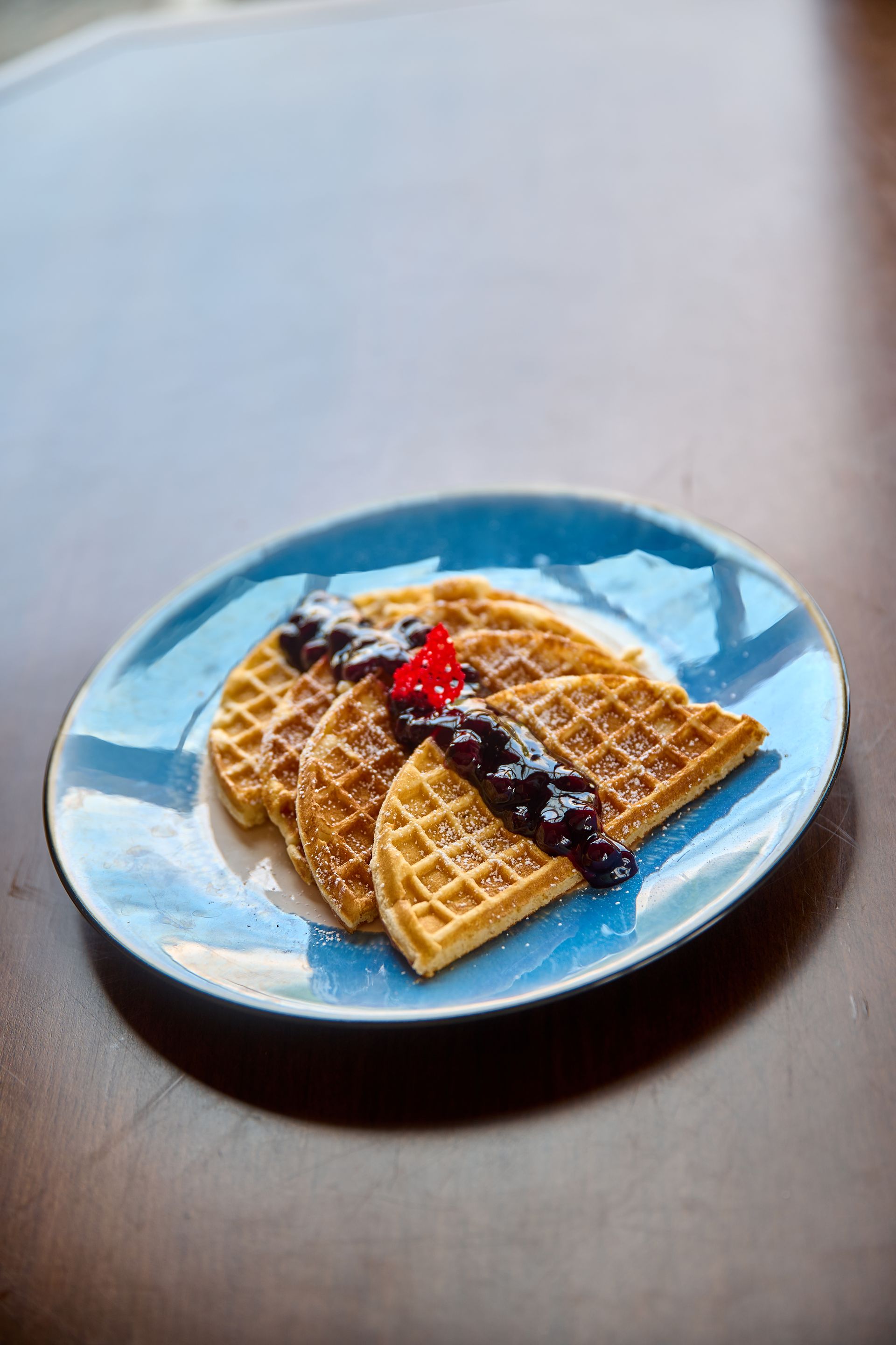 Golden waffles with berry compote on blue plate at Aurora Subic Hotel