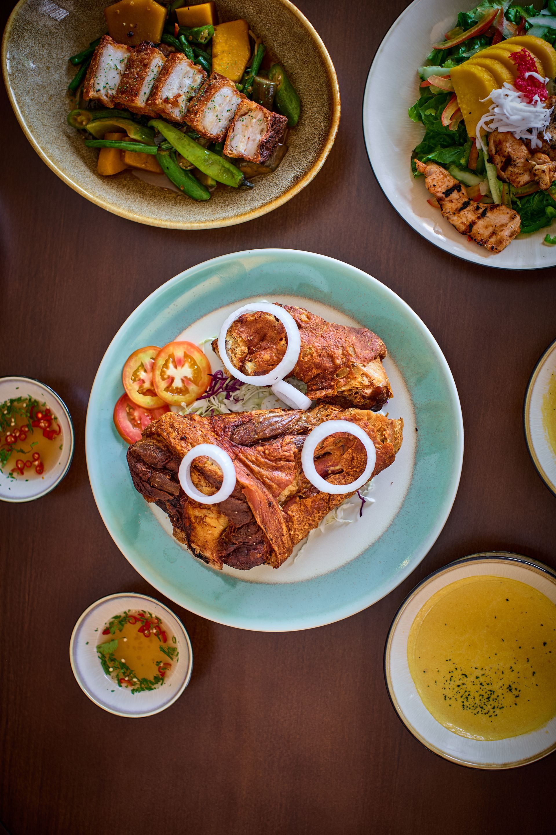 Filipino feast spread with crispy pork, grilled dishes, and dipping sauces