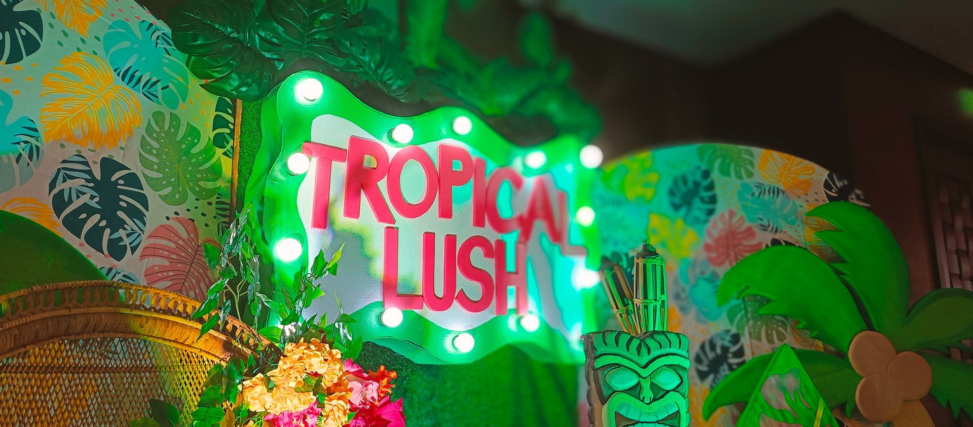 A neon sign that says 'tropical lush' hanging in an event room at a hotel in subic