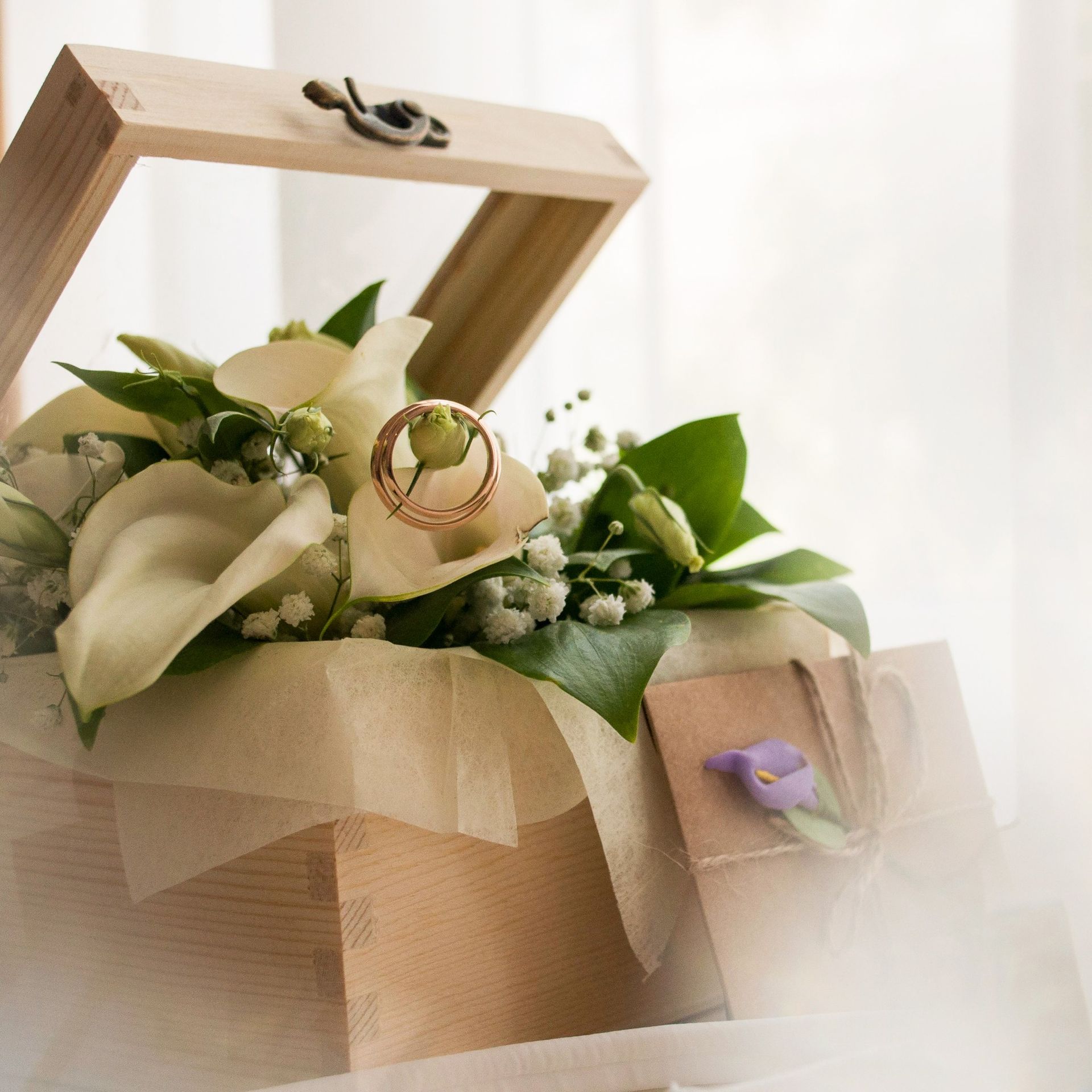 A box filled with flowers and wedding rings
