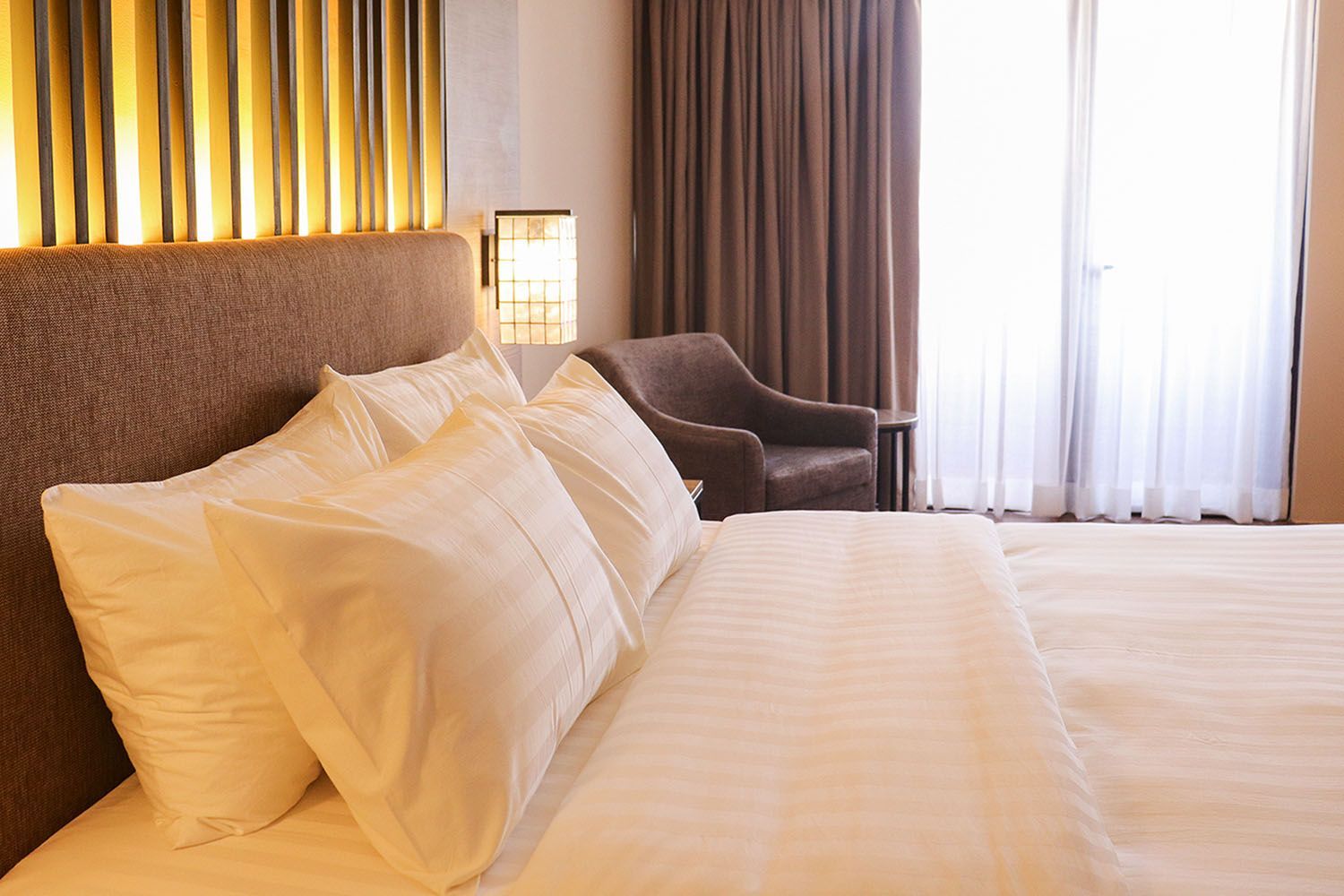 Luxurious hotel room with white bedding and warm lighting at Aurora Subic