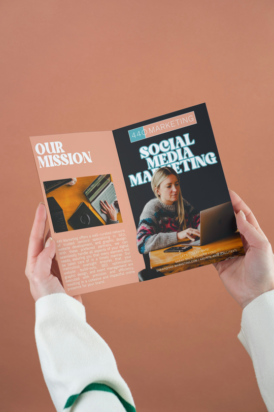 Hands holding an open brochure titled "Social Media Marketing." The spread shows images and text on a peach-colored backdrop.