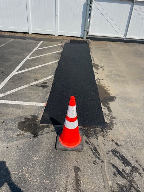 An orange and white traffic cone in a parking lot