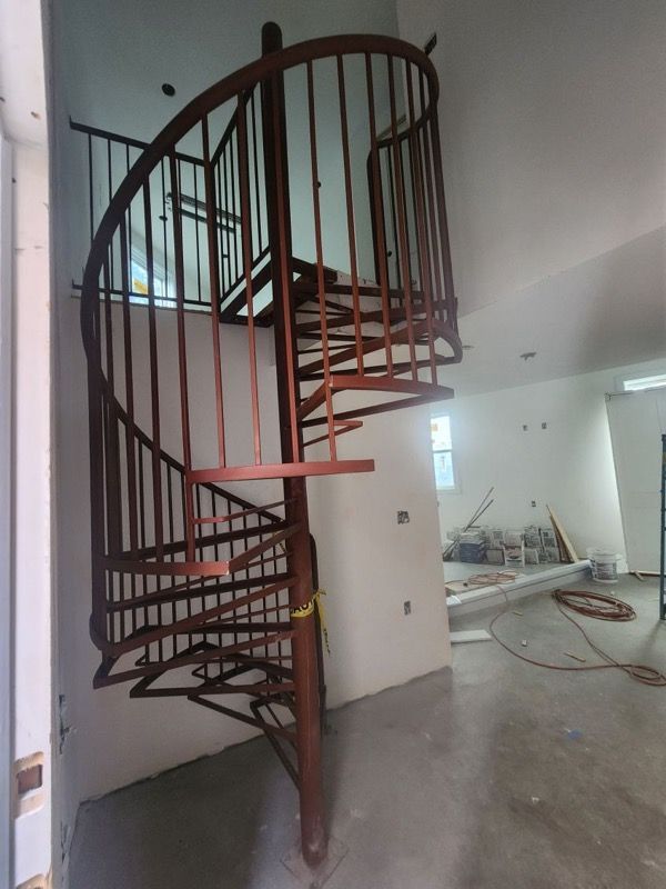 A spiral staircase in a room with white walls