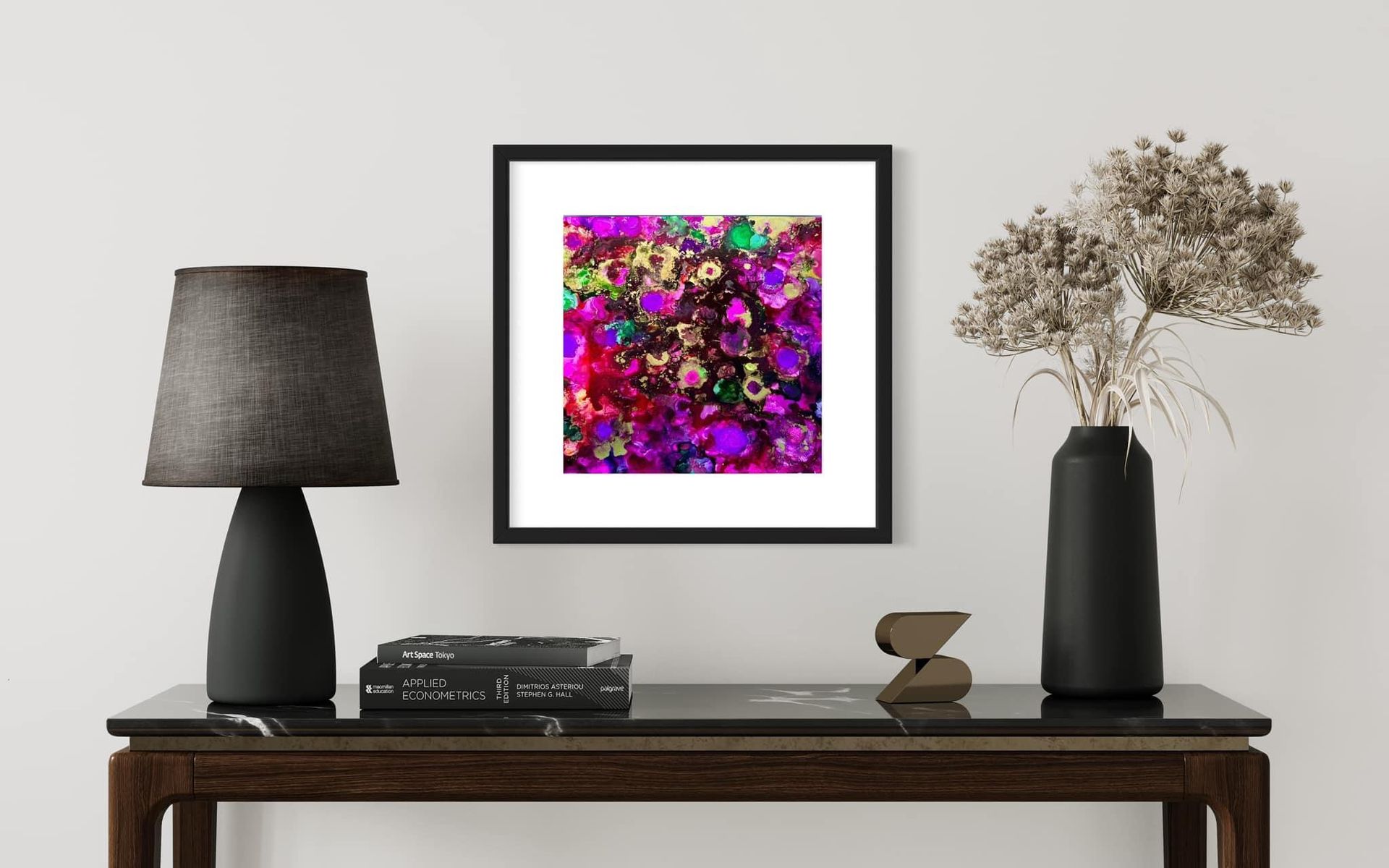 A framed painting is hanging on a wall above a table.