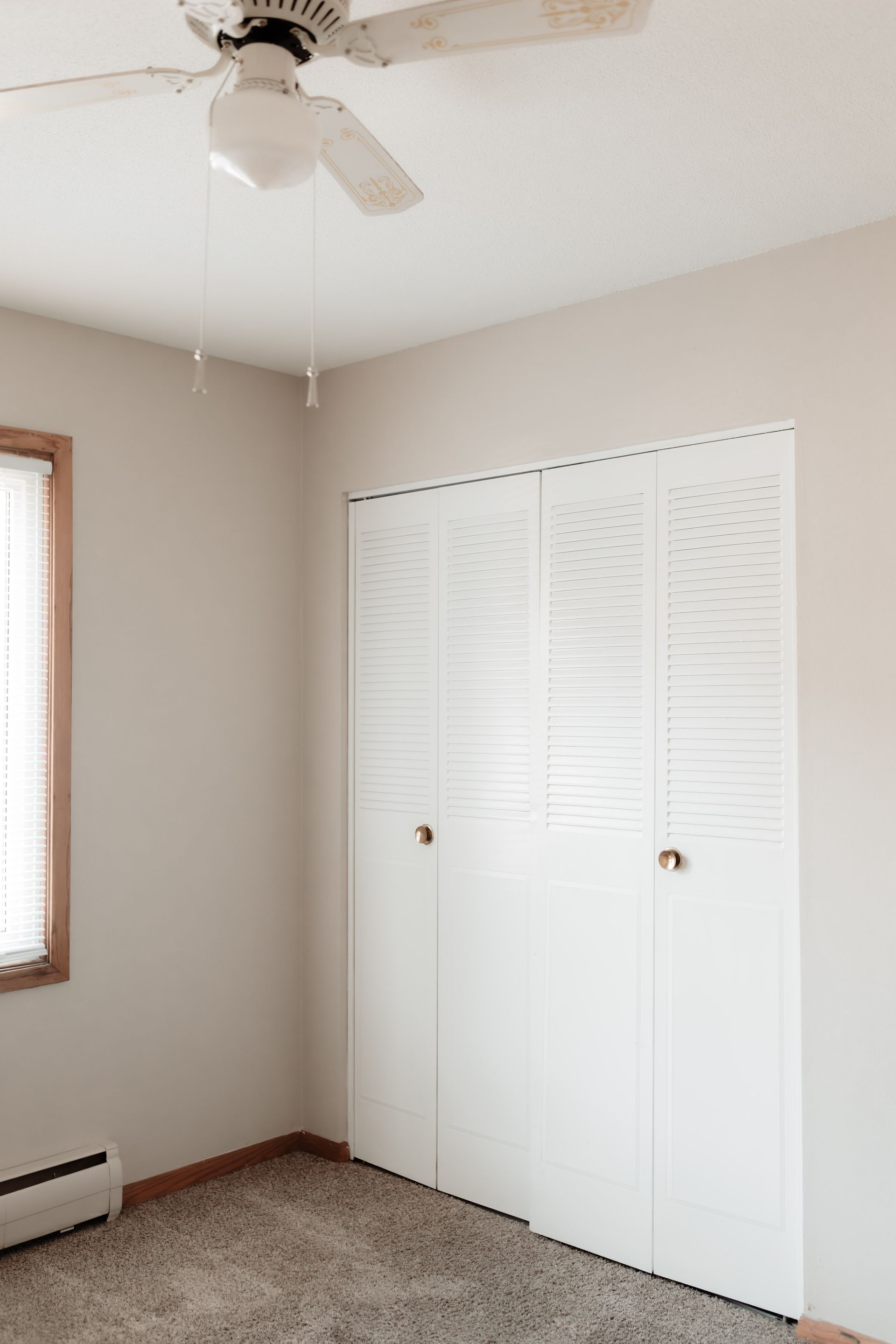 Light from a large window reflects onto vintage closet doors. Apartment in Northeast Minneapolis by RightMove Properties. 