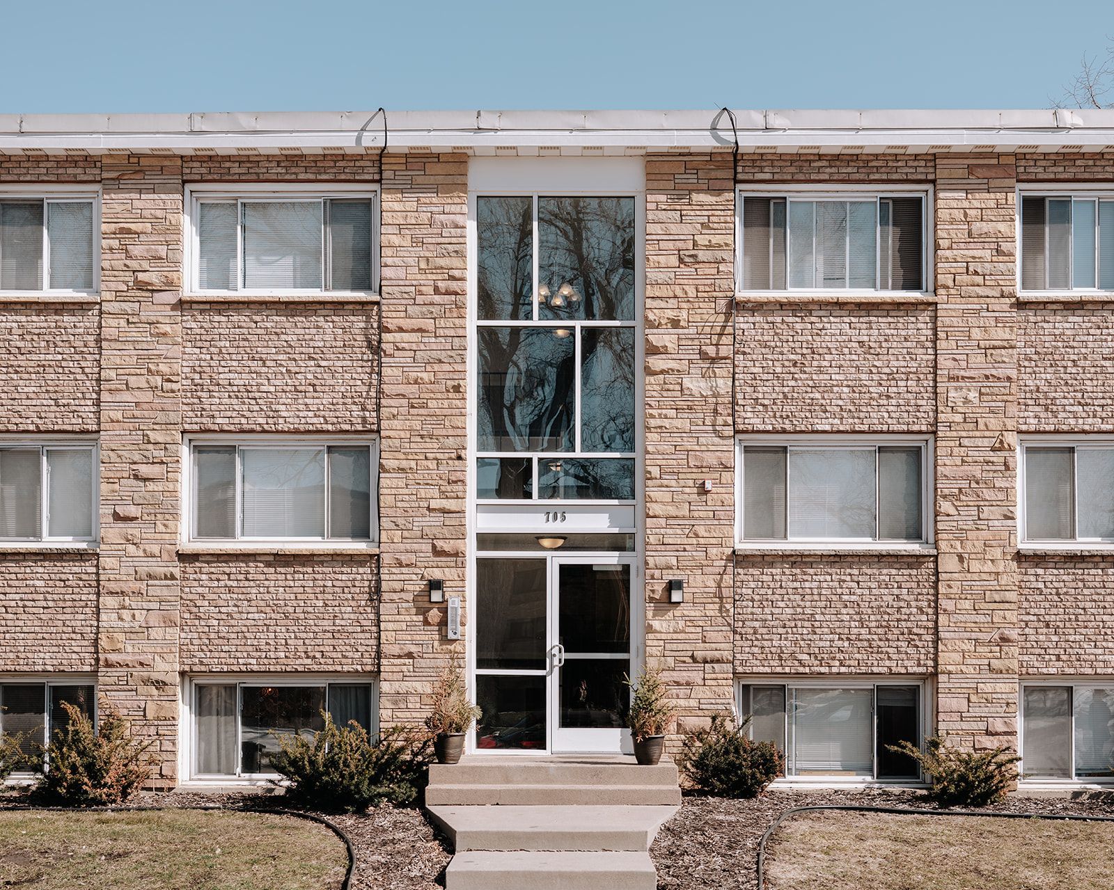 Brick exterior of an apartment building with large windows and landscaping. Apartment in Northeast Minneapolis by RightMove Properties. 