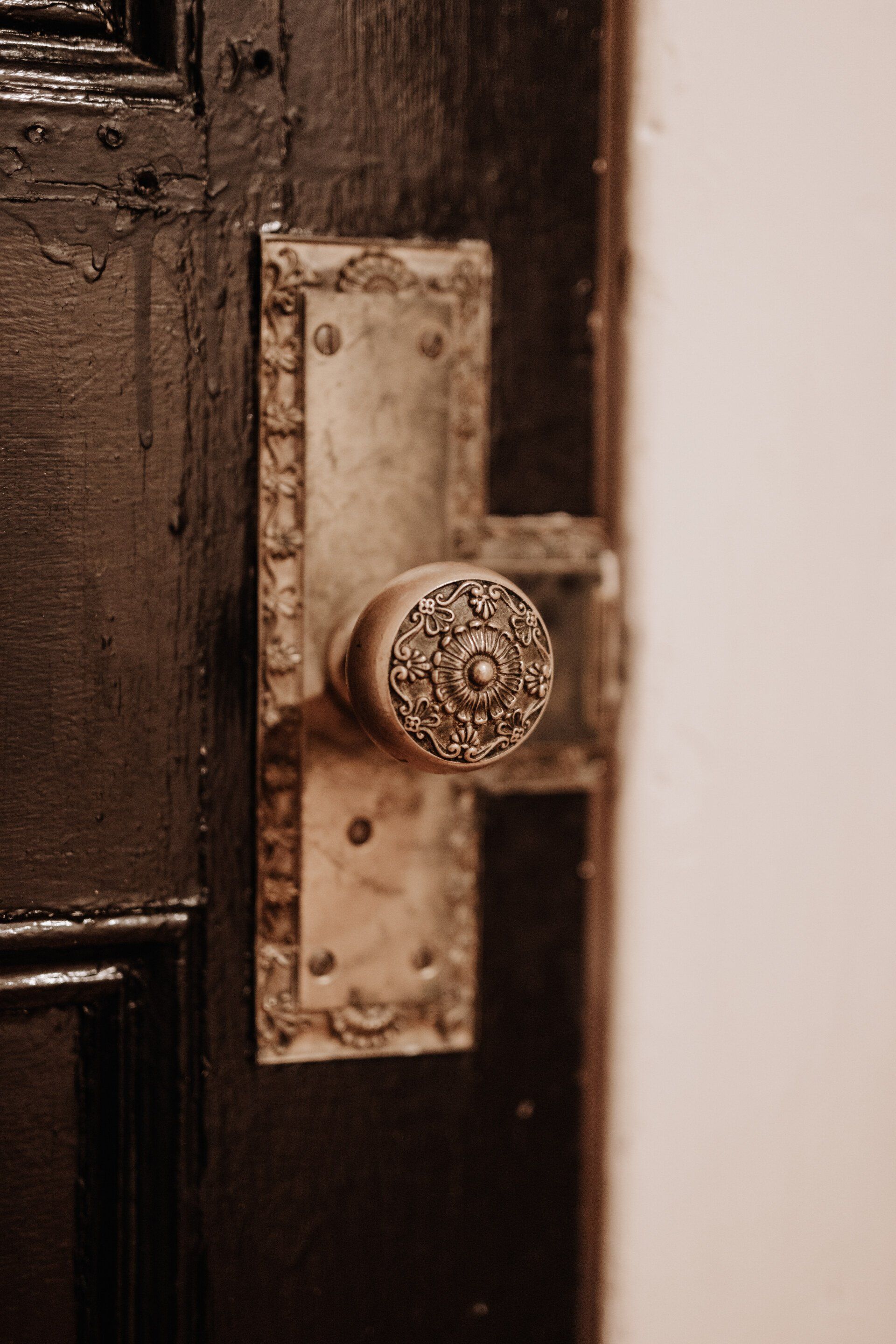 Incredibly ornate gold doorknob on a vintage wooden door. South Minneapolis apartments by RightMove Properties.