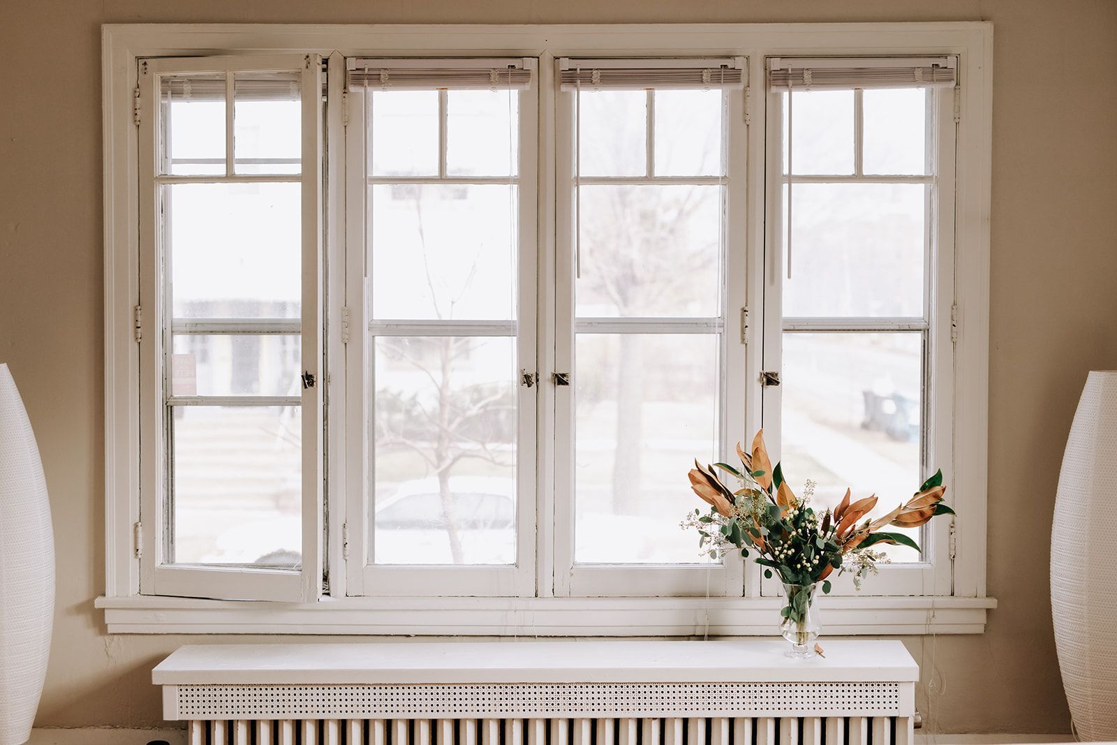 A set of vintage windows. A bouquet sits on the radiator in front. South Minneapolis apartments by RightMove Properties.