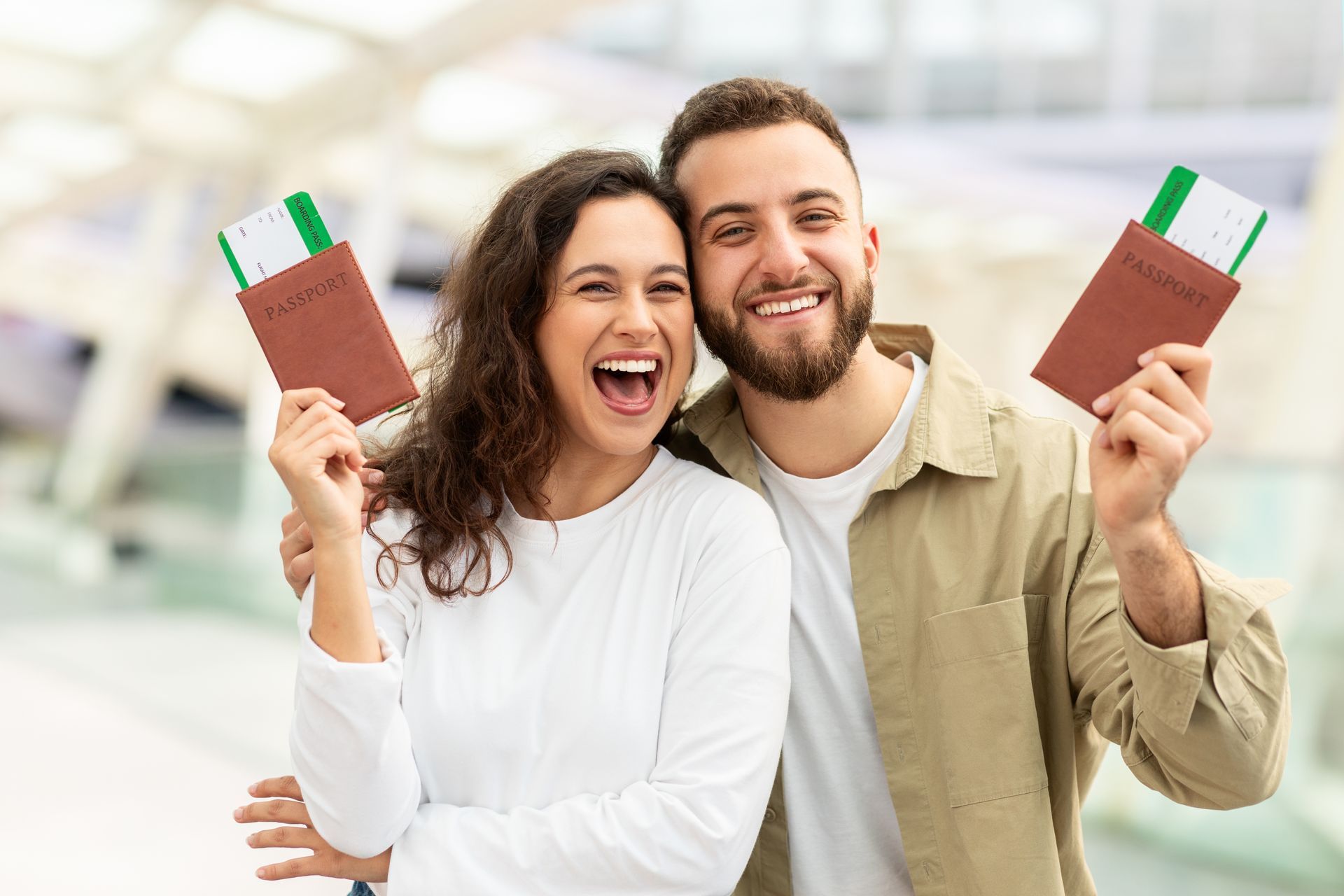 Smiling couple holding chocolate bars, standing together in a bright store aisle