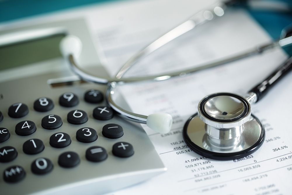 A stethoscope is sitting on top of a calculator.
