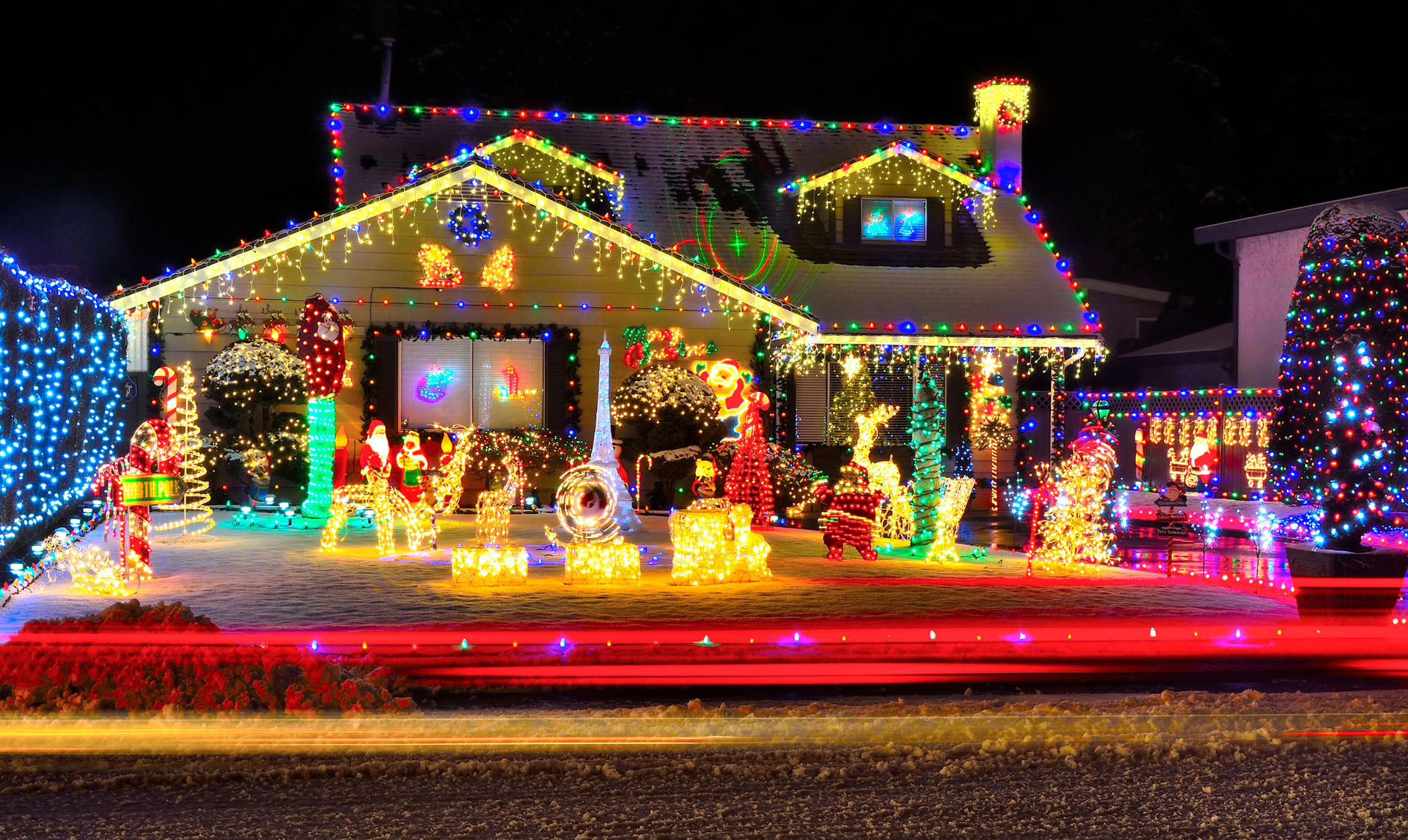 House decorated with Christmas lights and lawn ornaments; red, green, and white.