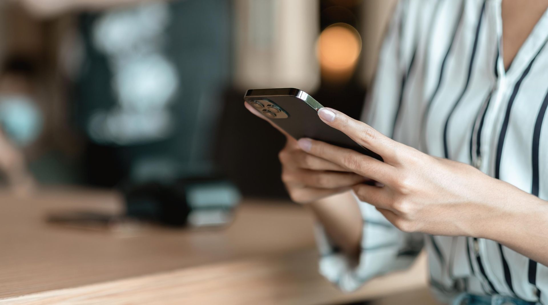 A woman is holding a cell phone in her hands.