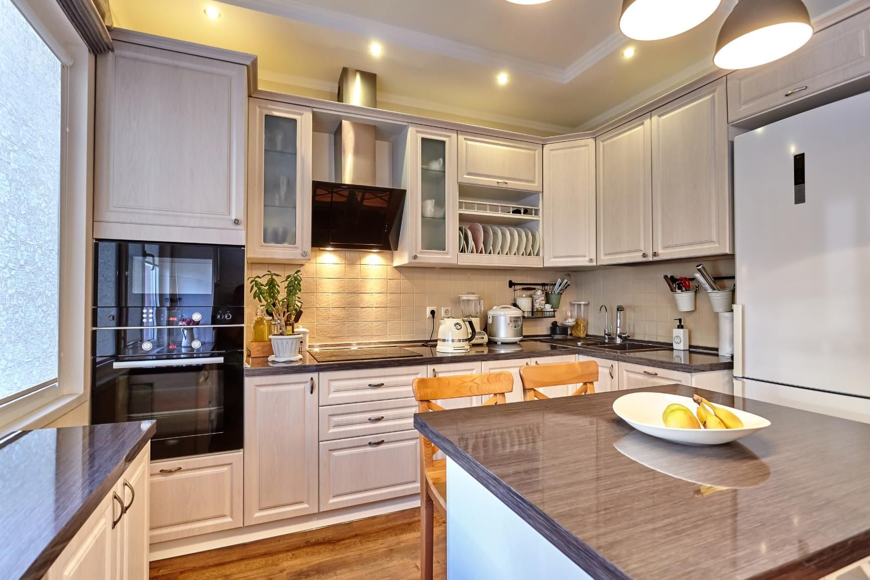 A kitchen with white cabinets and a granite counter top.