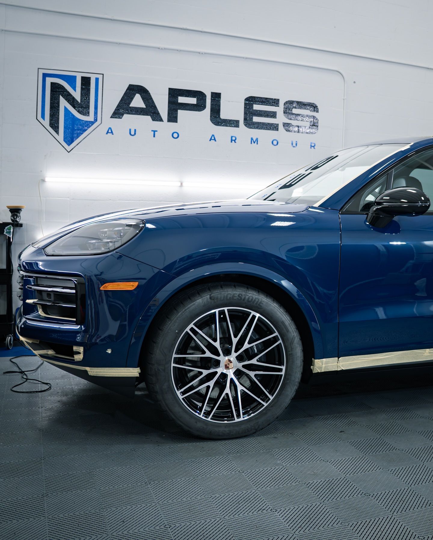 Blue Porsche receiving ceramic coating at Naples Auto Armour.