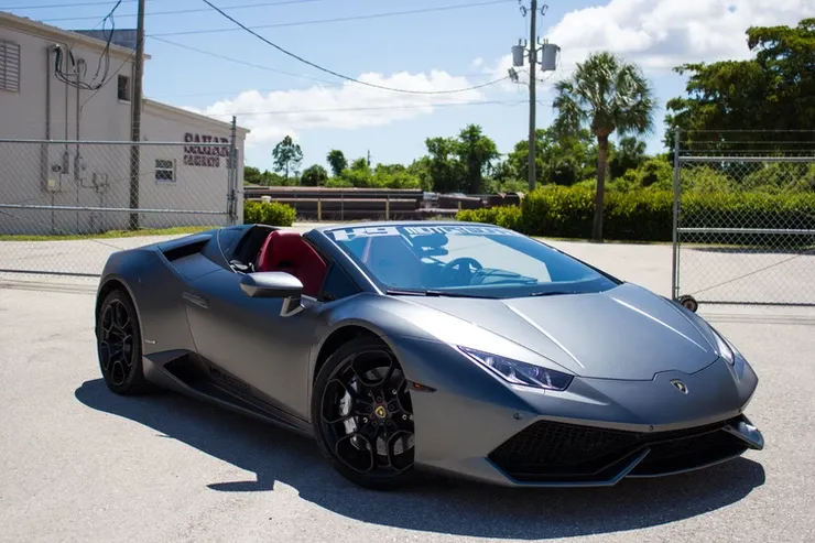 A silver lamborghini huracan is parked in a parking lot