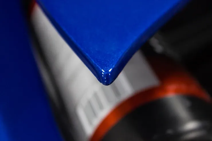 A close up of a blue piece of paper next to a bottle