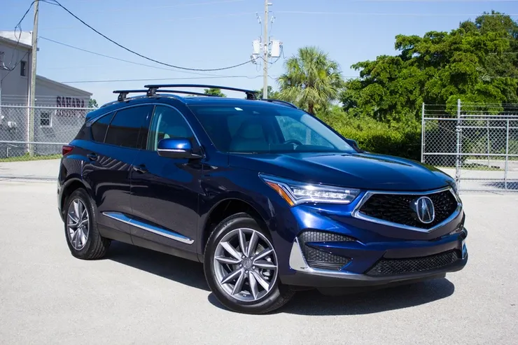 A blue acura rx is parked on the side of the road.