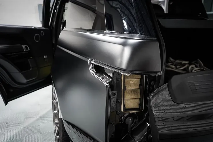 The back of a black range rover with the door open.