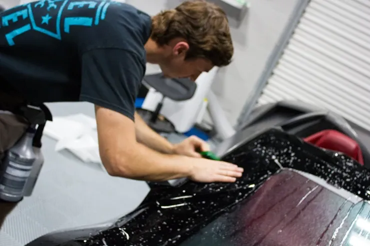 A man in a black shirt is working on a car