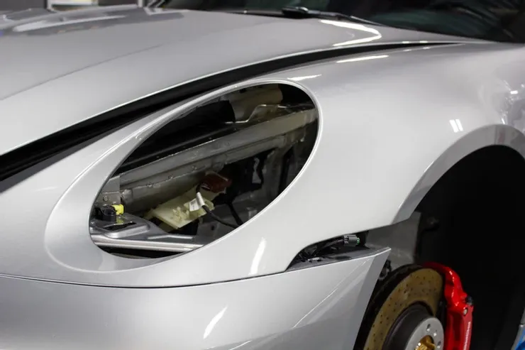 A close up of a silver car with the hood open