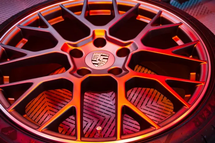 A close up of a car wheel with a porsche logo on it