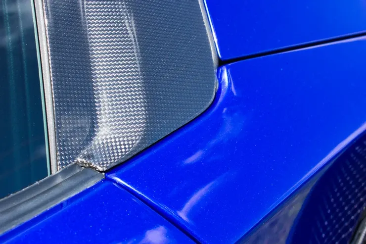 A close up of a blue car with a chrome trim.