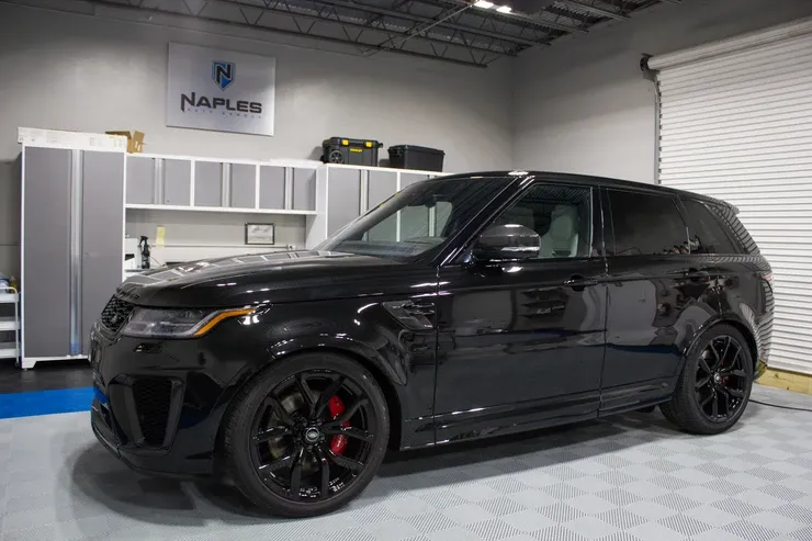 A black range rover sport is parked in a garage.