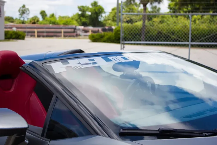 A close up of a car windshield with a sticker on it