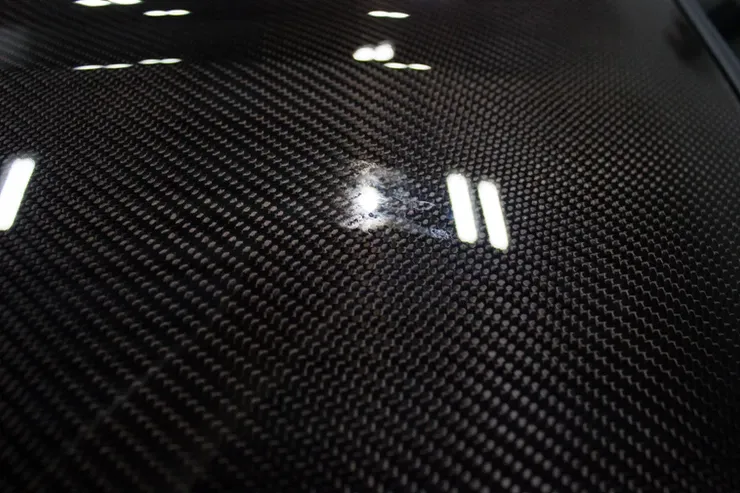 A close up of a black carbon fiber surface