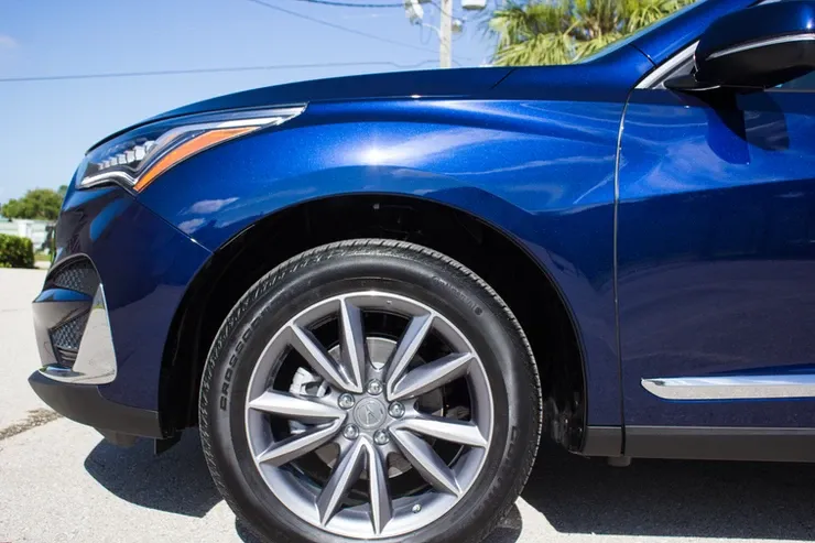 A blue car is parked on the side of the road.