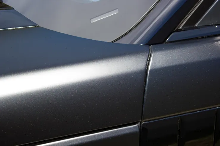 A close up of a car 's hood and windshield