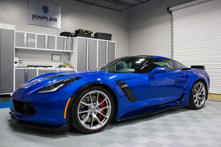 A blue sports car is parked in a garage.