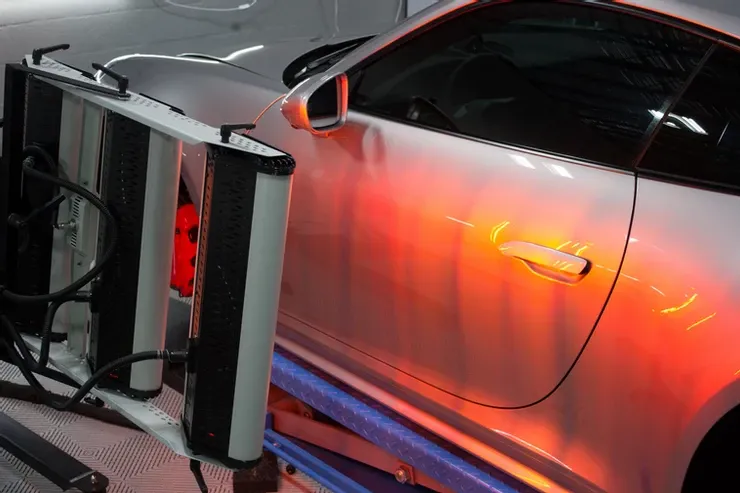 A car is sitting on a lift with a red light on it.
