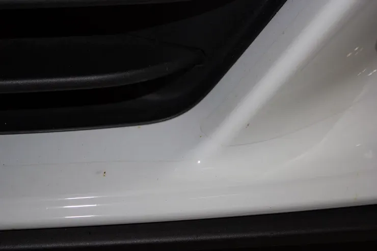 A close up of the front bumper of a white car.