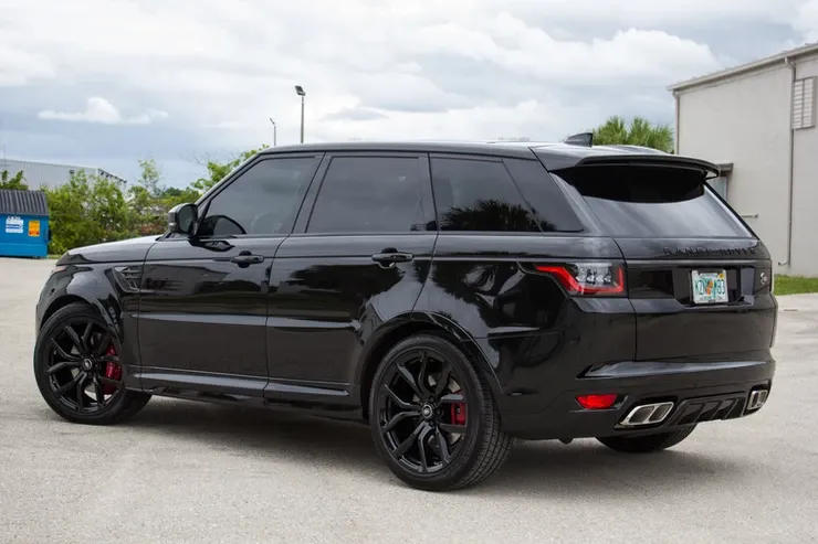 A black range rover sport is parked in a parking lot.