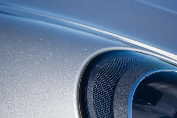 A close up of a car 's hood with a speaker on it.