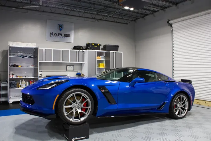A blue sports car is parked in a garage.
