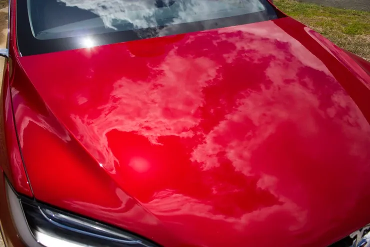 A close up of the hood of a red car.
