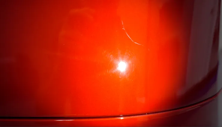 A close up of a red object with a light shining on it.