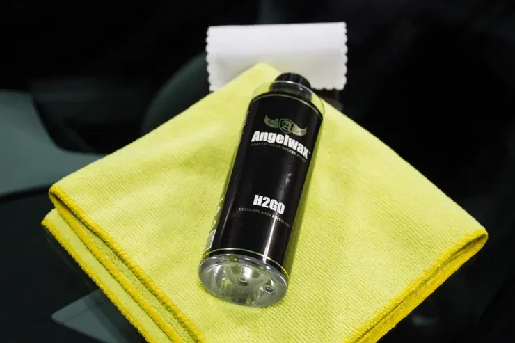 A bottle of angel wax sits on a yellow cloth