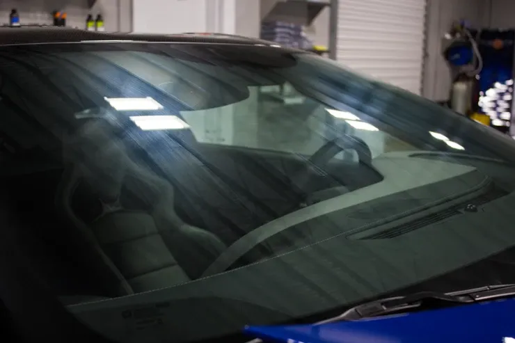 A close up of a car windshield in a garage