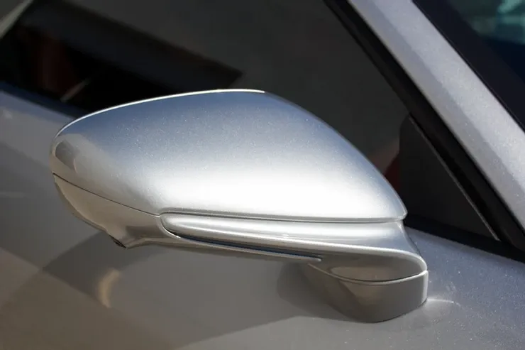 A close up of a silver car 's side mirror