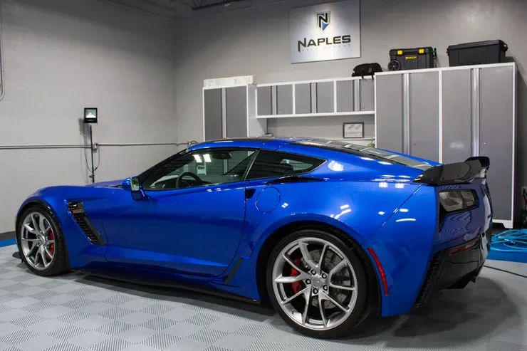 A blue sports car is parked in a garage.