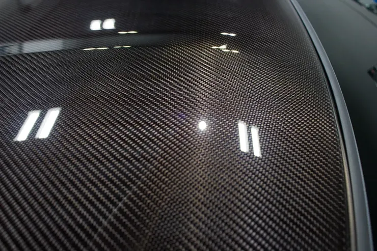 A close up of a carbon fiber roof of a car.